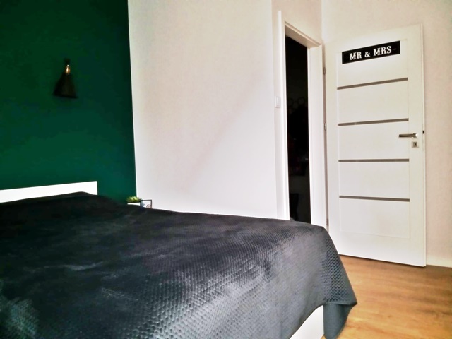 ruda chata-blog-sypialnia z zieloną scianą-butelkowa zieleń-białe łóżko-jasna sypialnia-białe drzwi